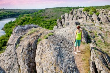 Kız bir sırt çantası ile pitoresk yerlerde yürür.