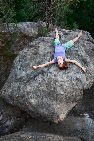 Das Mädchen entspannt sich auf dem Stein. — Stockfoto