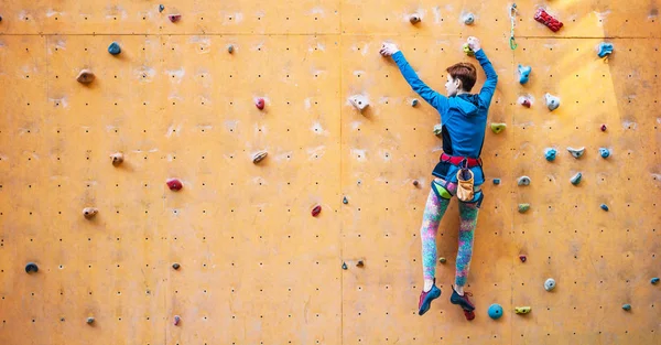 A menina sobe na parede de escalada . — Fotografia de Stock