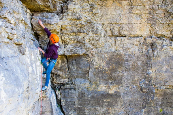 La mujer en el casco sube a la roca . — Foto de Stock