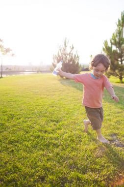 Çocuk çim çalışan bir şişeyle.