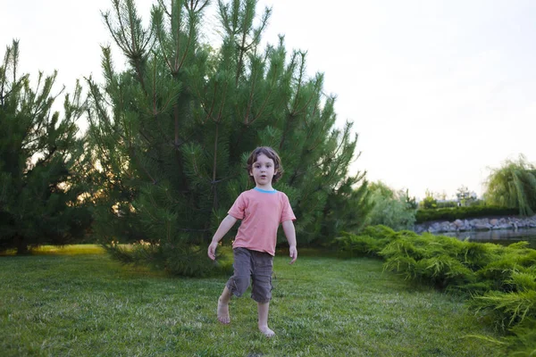 Çocuk çimenlerin üzerinde duruyor. — Stok fotoğraf