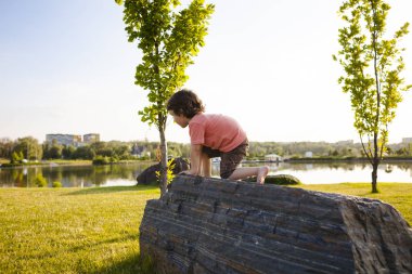 Çocuk taş üzerine tırmandı.