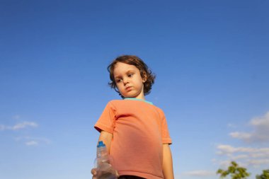 Çocuk bir şişe su ile.