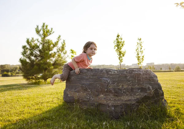 Dziecko, wspiął się na kamieniu. — Zdjęcie stockowe