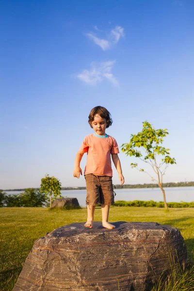 A criança subiu na pedra. — Fotografia de Stock