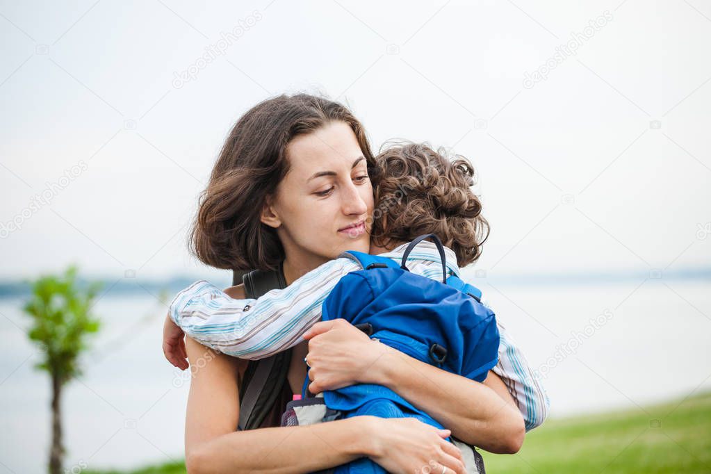 A woman is hugging a boy.