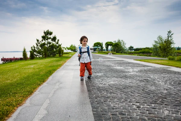 Bir çocuk sabun köpüğü ile oynuyor.
