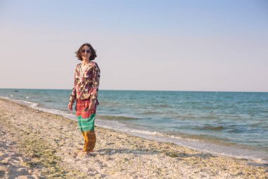 Bir kız sahilde yürüyor.