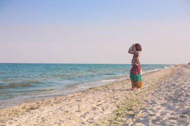 Bir kız sahilde yürüyor.