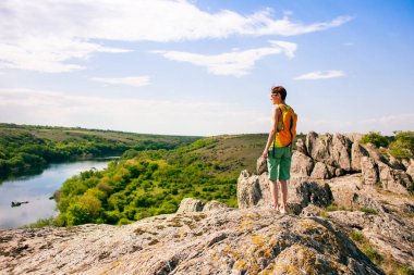 Kız bir sırt çantası ile pitoresk yerlerde yürür.
