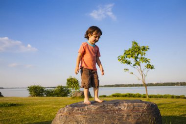 Çocuk taş üzerine tırmandı.