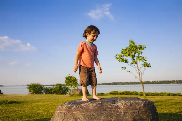 Çocuk taş üzerine tırmandı.