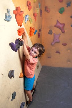 Çocuk dağcı duvara tırmanıyor.