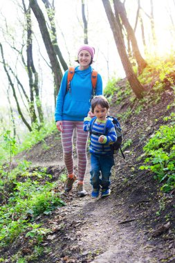 Çocuk ve annesi ormana doğru yürüyor.