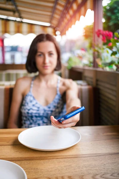 Restoranda kız telefonu tutan.