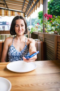 Restoranda kız telefonu tutan.