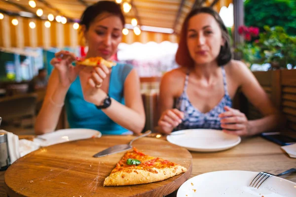Duas raparigas estão a comer pizza. . — Fotografia de Stock