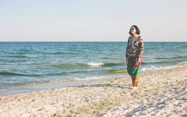 Bir kız sahilde yürüyor.