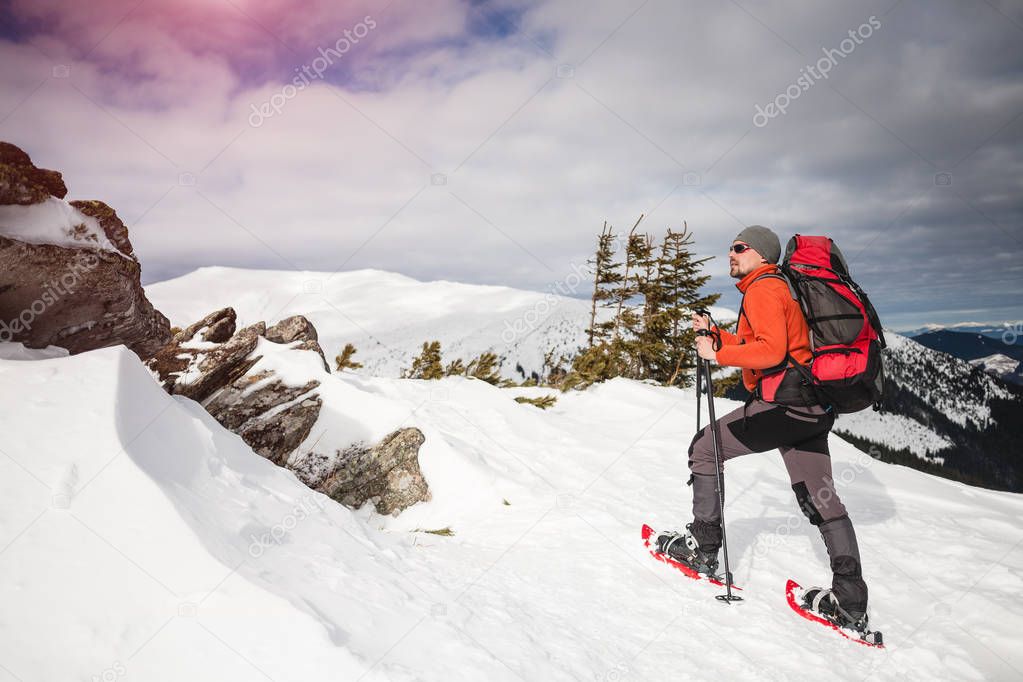 Male tourist in snow snowshoes.