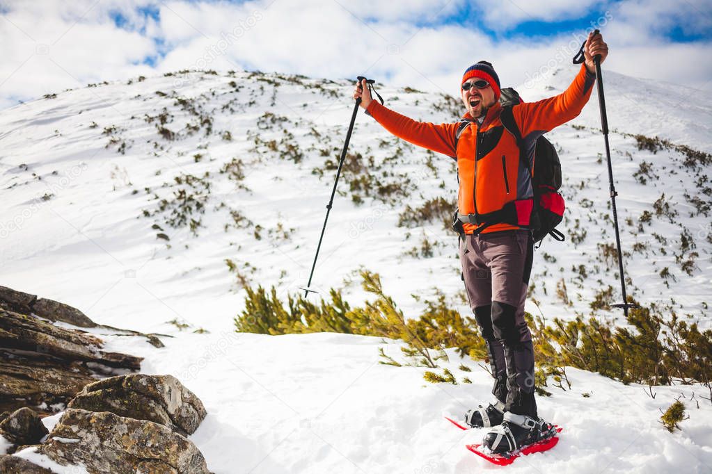 Male tourist in snow snowshoes.