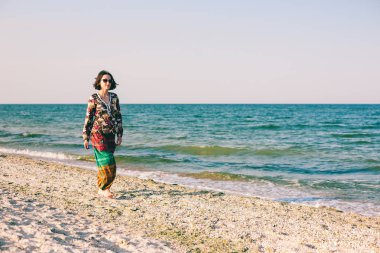 Bir kız sahilde yürüyor.