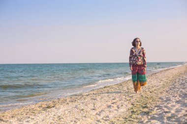 Bir kız sahilde yürüyor.