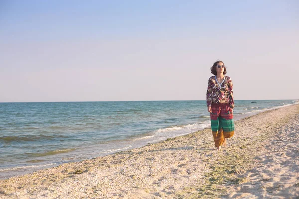 Bir kız sahilde yürüyor.