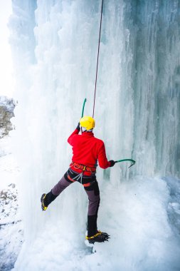 Dağcı buza tırmanıyor.