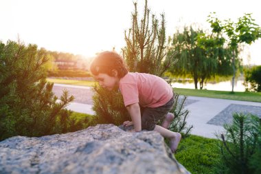 Çocuk taşa tırmanıyor.