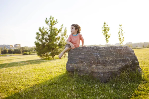 The boy climbs on the stone. — Stock Photo, Image