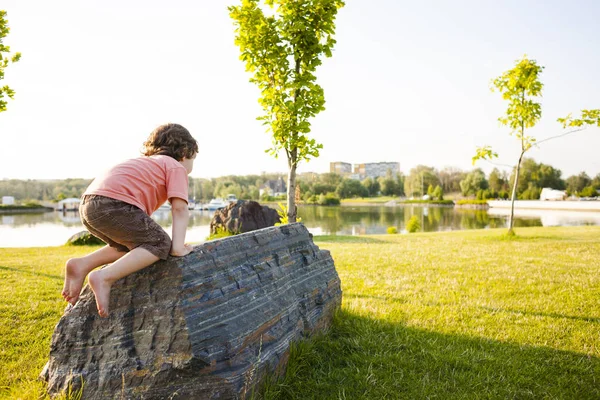 Çocuk taş üzerine tırmandı.