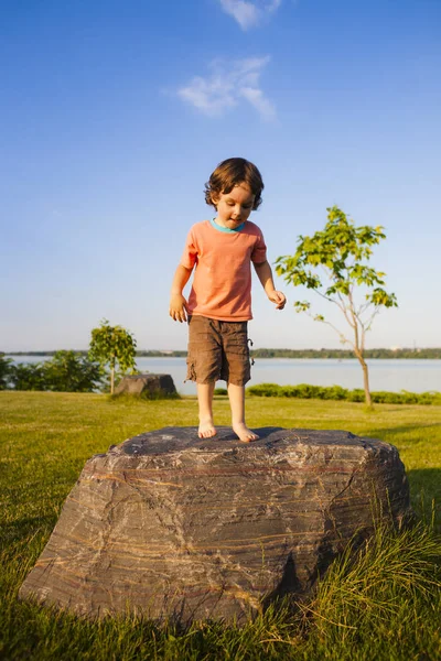 Barnet klättrade på stenen. — Stockfoto