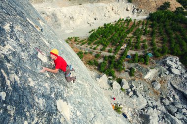 Bir adam kaya tırmanıyor.