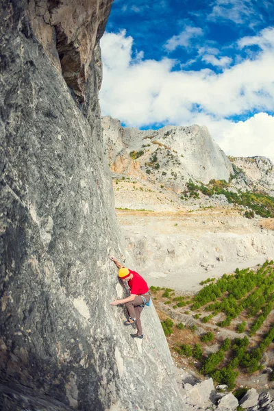 Un grimpeur dans un chapeau sur un rocher . — Photo