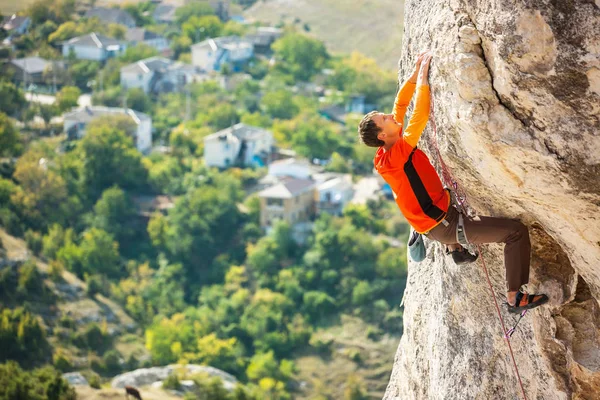 Un escalador en un sombrero en una roca . — Foto de Stock