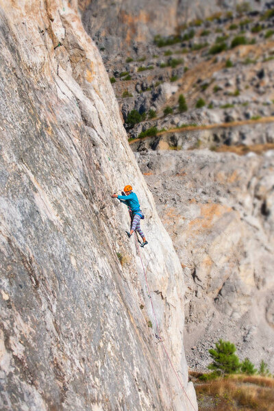 The girl climbs the rock.