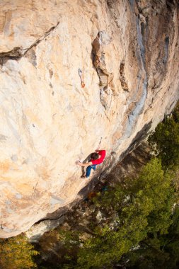 Bir dağcı bir kayanın üzerinde.