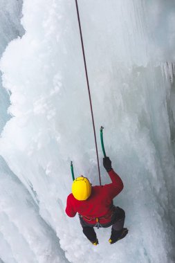 Dağcı buza tırmanıyor.
