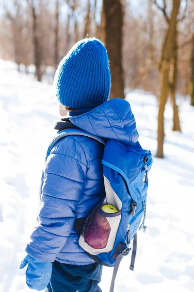 Хлопчик з рюкзаком в лісі взимку . — стокове фото