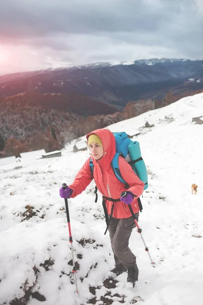 Chica con mochila caminando en la nieve en las montañas . —  Fotos de Stock