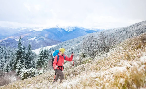 Девушка с рюкзаком ходит по снегу в горах . — стоковое фото