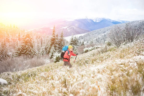 Mädchen mit Rucksack auf Schnee in den Bergen. — Stockfoto