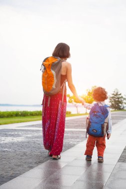 Çocuk annesiyle birlikte yürür.