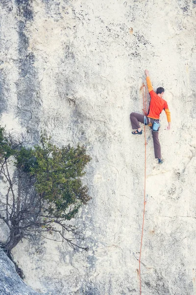 Un hombre sube a la roca . — Foto de Stock