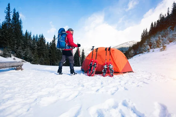 Escalador perto da tenda com sapatos de neve . — Fotografia de Stock