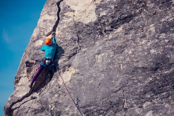 Das Mädchen erklimmt den Felsen. — Stockfoto