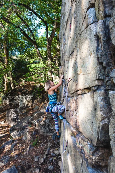 Chica escalador en una roca . — Foto de Stock