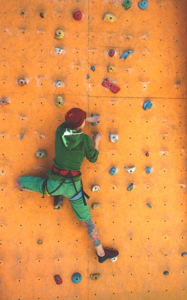 Das Mädchen klettert an der Kletterwand. — Stockfoto