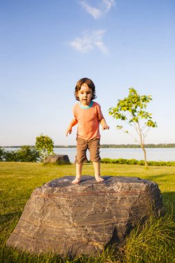 Çocuk taş üzerine tırmandı.